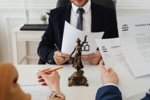 pexels-photo-7876050-7876050 Legal professionals reviewing divorce documents in a law office with a Lady Justice statue.