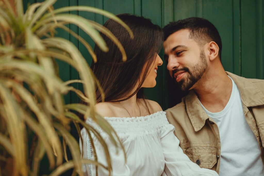 Charming couple sharing a romantic moment outdoors with vibrant greenery.